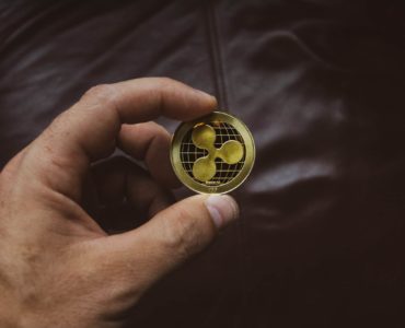 person-holding-round-gold-colored-coin